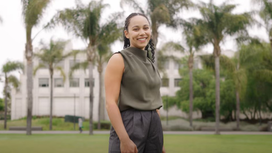 A student in business wear standing in front of the Hilton Center for Business on the LMU Westchester campus.